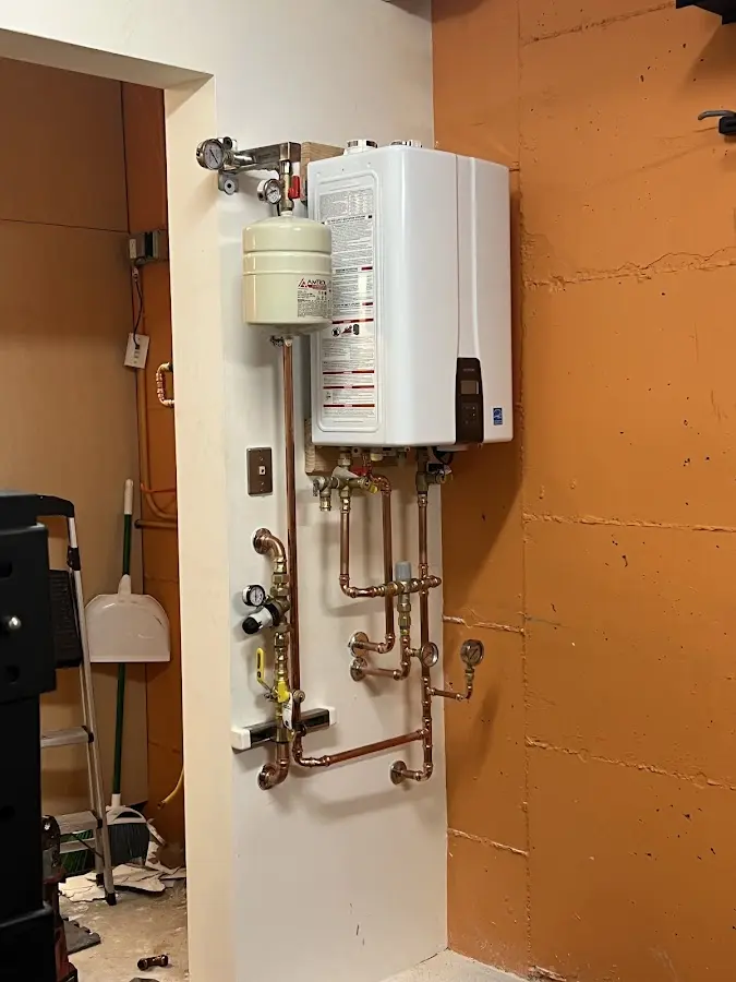 Plumbing technician inspecting water heater connections in Palmer